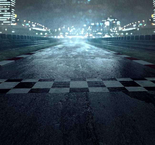 Nächtliche, beregnete Rennstrecke verliert sich am Horizont in beleuchteter Stadt